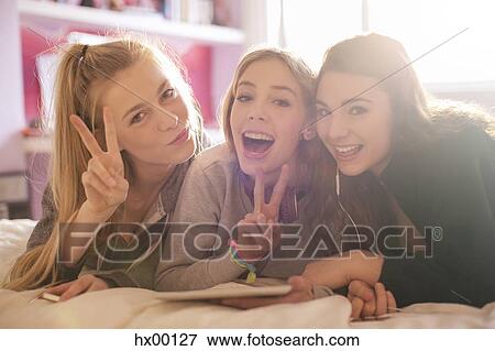 Portrait teenage girls gesturing peace sign View Large Photo Image Stock Photo - Portrait teenage girls gesturing peace sign. Fotosearch