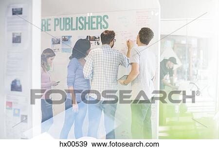 Stock Photo - Publishers brainstorming at whiteboard in office. Fotosearch