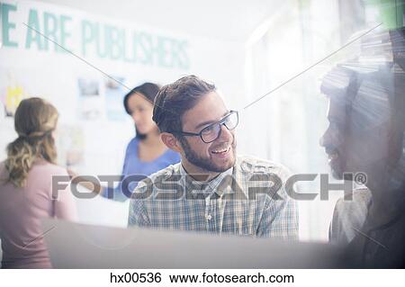 Publishers talking in sunny office View Large Photo Image Stock Photograph - Publishers talking in sunny office. Fotosearch