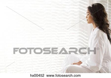 Serene woman in bathrobe meditating at sunny window View Large Photo Image Stock Image - Serene woman in bathrobe meditating at sunny window. Fotosearch