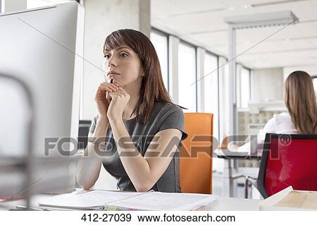 Stock Photo - Serious businesswoman working at computer in office. Fotosearch