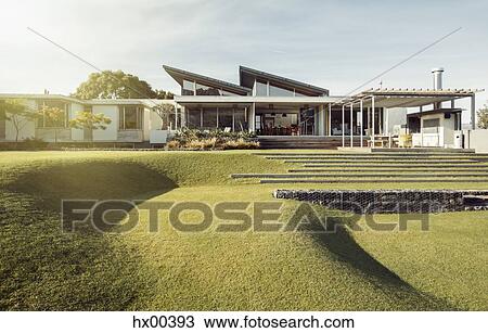 Sloped green yard and luxury house View Large Photo Image Stock Image - Sloped green yard and luxury house. Fotosearch