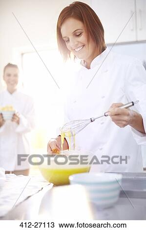 Stock Image - Smiling chef baking in kitchen. Fotosearch