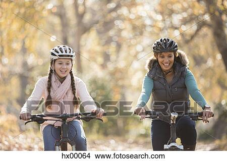 Smiling mother and daughter bike riding outdoors View Large Photo Image Picture - Smiling mother and daughter bike riding outdoors. Fotosearch