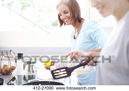 Smiling women cooking in kitchen View Large Photo Image Stock Image - Smiling women cooking in kitchen. Fotosearch