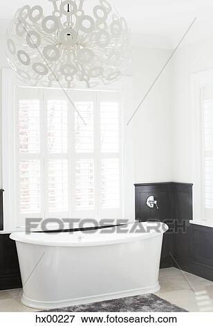 Soaking tub and modern chandelier in luxury bathroom View Large Photo Image Stock Photo - Soaking tub and modern chandelier in luxury bathroom. Fotosearch