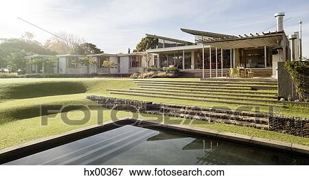 Stock Photo - Sunny yard and house with swimming pool. Fotosearch