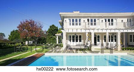 Stock Image - Swimming pool outside luxury house. Fotosearch