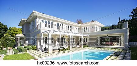 Stock Photograph - Swimming pool outside luxury house. Fotosearch