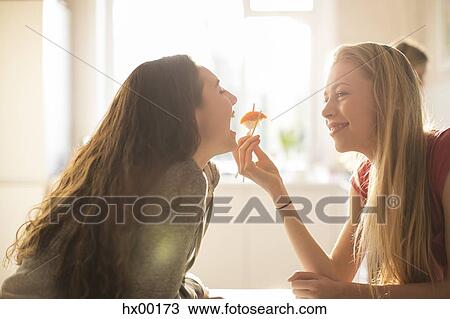 Teenage girl feeding friend sushi with chopsticks View Large Photo Image Stock Image - Teenage girl feeding friend sushi with chopsticks. Fotosearch