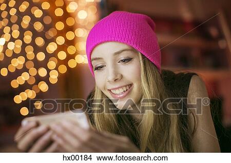 Teenage girl in pink beanie texting with cell phone View Large Photo Image Picture - Teenage girl in pink beanie texting with cell phone. Fotosearch