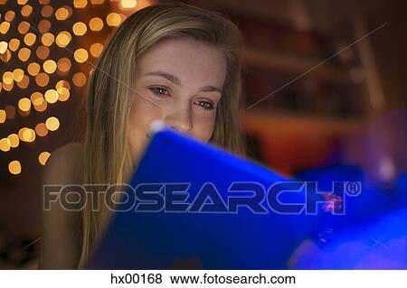 Teenage girl using digital tablet in dark room View Large Photo Image Stock Photo - Teenage girl using digital tablet in dark room. Fotosearch