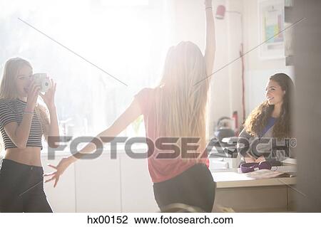 Teenage girls dancing and photographing in kitchen View Large Photo Image Stock Image - Teenage girls dancing and photographing in kitchen. Fotosearch