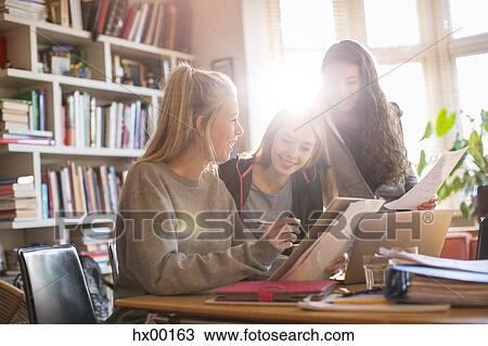 Stock Image - Teenage girls doing homework. Fotosearch