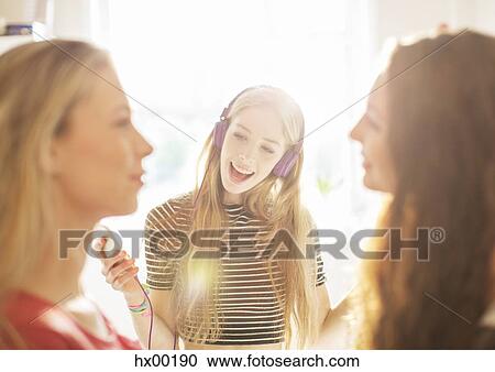 Teenage girls hanging out listening to music with headphones View Large Photo Image Stock Image - Teenage girls hanging out listening to music with headphones. Fotosearch