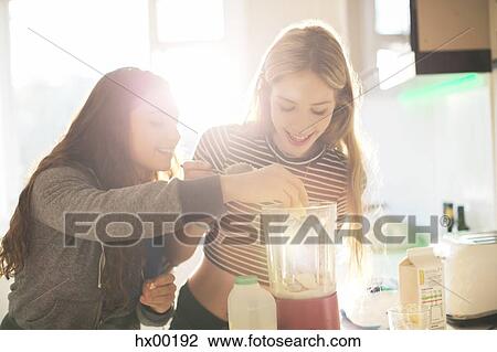 Teenage girls making smoothie in sunny kitchen View Large Photo Image Stock Image - Teenage girls making smoothie in sunny kitchen. Fotosearch