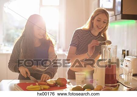 Teenage girls making smoothie in sunny kitchen View Large Photo Image Stock Photograph - Teenage girls making smoothie in sunny kitchen. Fotosearch