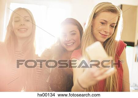 Teenage girls taking selfie with camera phone View Large Photo Image Picture - Teenage girls taking selfie with camera phone. Fotosearch