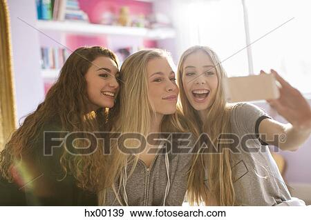 Teenage girls taking selfie with camera phone View Large Photo Image Stock Photo - Teenage girls taking selfie with camera phone. Fotosearch