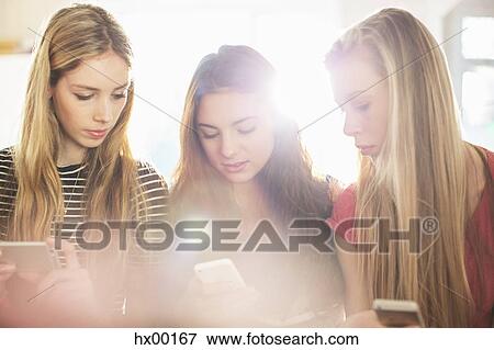 Teenage girls using cell phones View Large Photo Image Stock Photo - Teenage girls using cell phones. Fotosearch