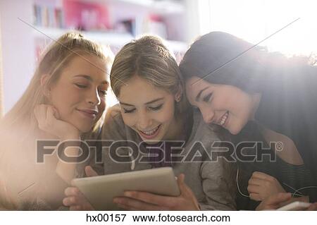 Teenage girls using digital tablet View Large Photo Image Stock Photo - Teenage girls using digital tablet. Fotosearch