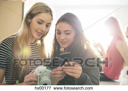 Teenage girls using instant camera View Large Photo Image Stock Photo - Teenage girls using instant camera. Fotosearch