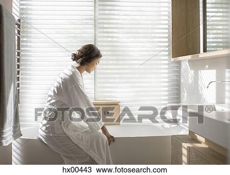 Woman in bathrobe drawing a bath in soaking tub in luxury bathroom View Large Photo Image Stock Image - Woman in bathrobe drawing a bath in soaking tub in luxury bathroom. Fotosearch
