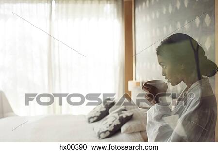 Woman in bathrobe sipping coffee in bedroom View Large Photo Image Stock Image - Woman in bathrobe sipping coffee in bedroom. Fotosearch