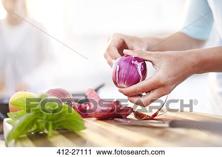 Woman peeling red onion in kitchen View Large Photo Image Stock Image - Woman peeling red onion in kitchen. Fotosearch