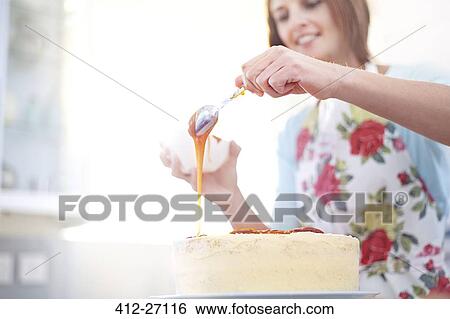Woman pouring caramel over cake baking in kitchen View Large Photo Image Stock Photograph - Woman pouring caramel over cake baking in kitchen. Fotosearch