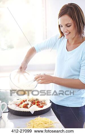 Woman preparing tomato quiche in kitchen View Large Photo Image Stock Photo - Woman preparing tomato quiche in kitchen. Fotosearch