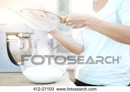 Woman sifting flour and baking in kitchen View Large Photo Image Stock Image - Woman sifting flour and baking in kitchen. Fotosearch