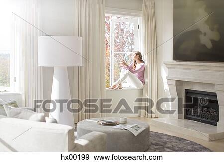 Woman sitting on sunny windowsill View Large Photo Image Stock Photo - Woman sitting on sunny windowsill. Fotosearch
