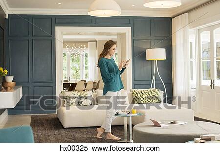 Woman texting with cell phone in home showcase living room View Large Photo Image Stock Photography - Woman texting with cell phone in home showcase living room. Fotosearch