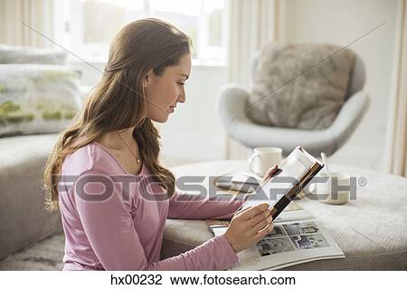 Woman using digital tablet in living room View Large Photo Image Stock Image - Woman using digital tablet in living room. Fotosearch
