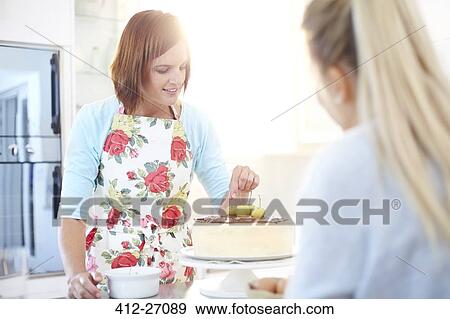 Stock Photo - Women baking cake in kitchen. Fotosearch