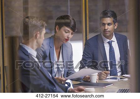 Picture - Business people reviewing paperwork in meeting. Fotosearch