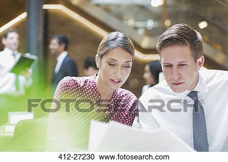 Business people reviewing paperwork in office View Large Photo Image Stock Image - Business people reviewing paperwork in office. Fotosearch