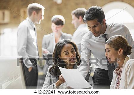 Business people reviewing paperwork in office View Large Photo Image Stock Image - Business people reviewing paperwork in office. Fotosearch