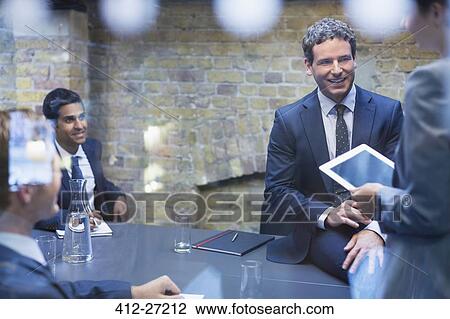 Stock Image - Business people talking in conference room. Fotosearch