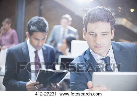 Businessman using digital tablet in office View Large Photo Image Stock Image - Businessman using digital tablet in office. Fotosearch