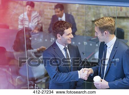 Businessmen handshaking outside conference room meeting View Large Photo Image Picture - Businessmen handshaking outside conference room meeting. Fotosearch