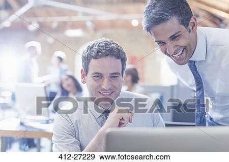 Businessmen working at laptop in office View Large Photo Image Stock Photo - Businessmen working at laptop in office. Fotosearch