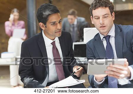 Stock Image - Businessmen working with digital tablet in office. Fotosearch