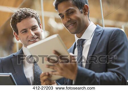 Businessmen working with digital tablet in office View Large Photo Image Stock Image - Businessmen working with digital tablet in office. Fotosearch