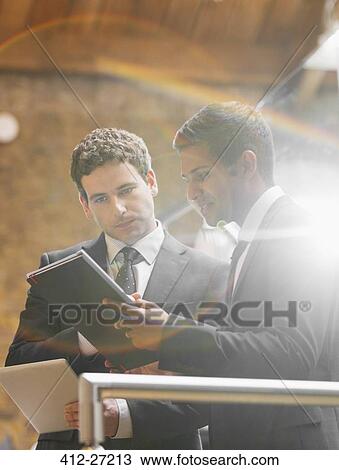 Businessmen working with digital tablet in office View Large Photo Image Stock Image - Businessmen working with digital tablet in office. Fotosearch