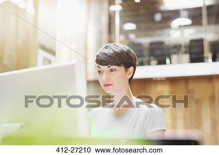 Businesswoman working at computer in office View Large Photo Image Stock Image - Businesswoman working at computer in office. Fotosearch