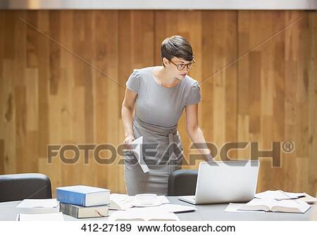 Stock Photo - Businesswoman working at laptop in office. Fotosearch