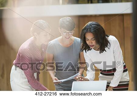 Stock Photograph - Businesswomen working at laptop in office. Fotosearch