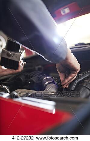 Close up mechanic arm reaching in car engine View Large Photo Image Stock Image - Close up mechanic arm reaching in car engine. Fotosearch
